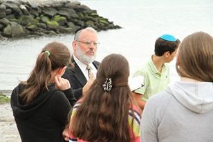 Rabbi Beer learning one-on-one with students by the Sound