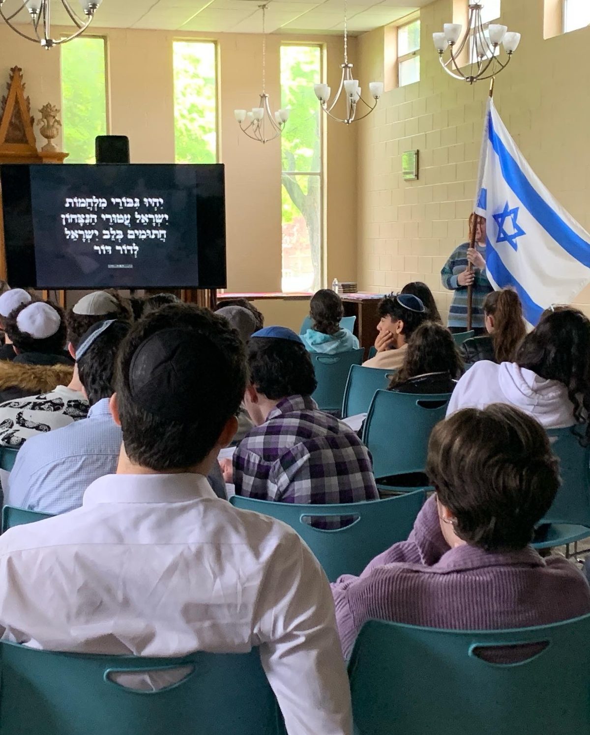 A WHHS assembly in the shul with the Israeli flag